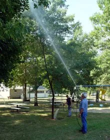 Sprinkler watering a shaded lawn